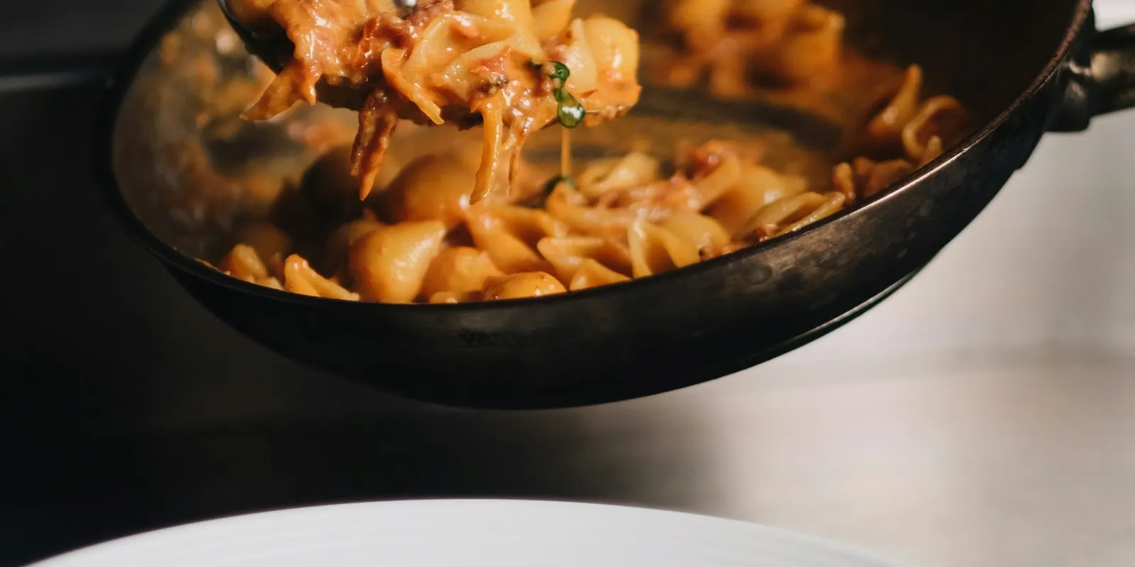 Pasta being tossed in a pan, filmed for a short recipe video