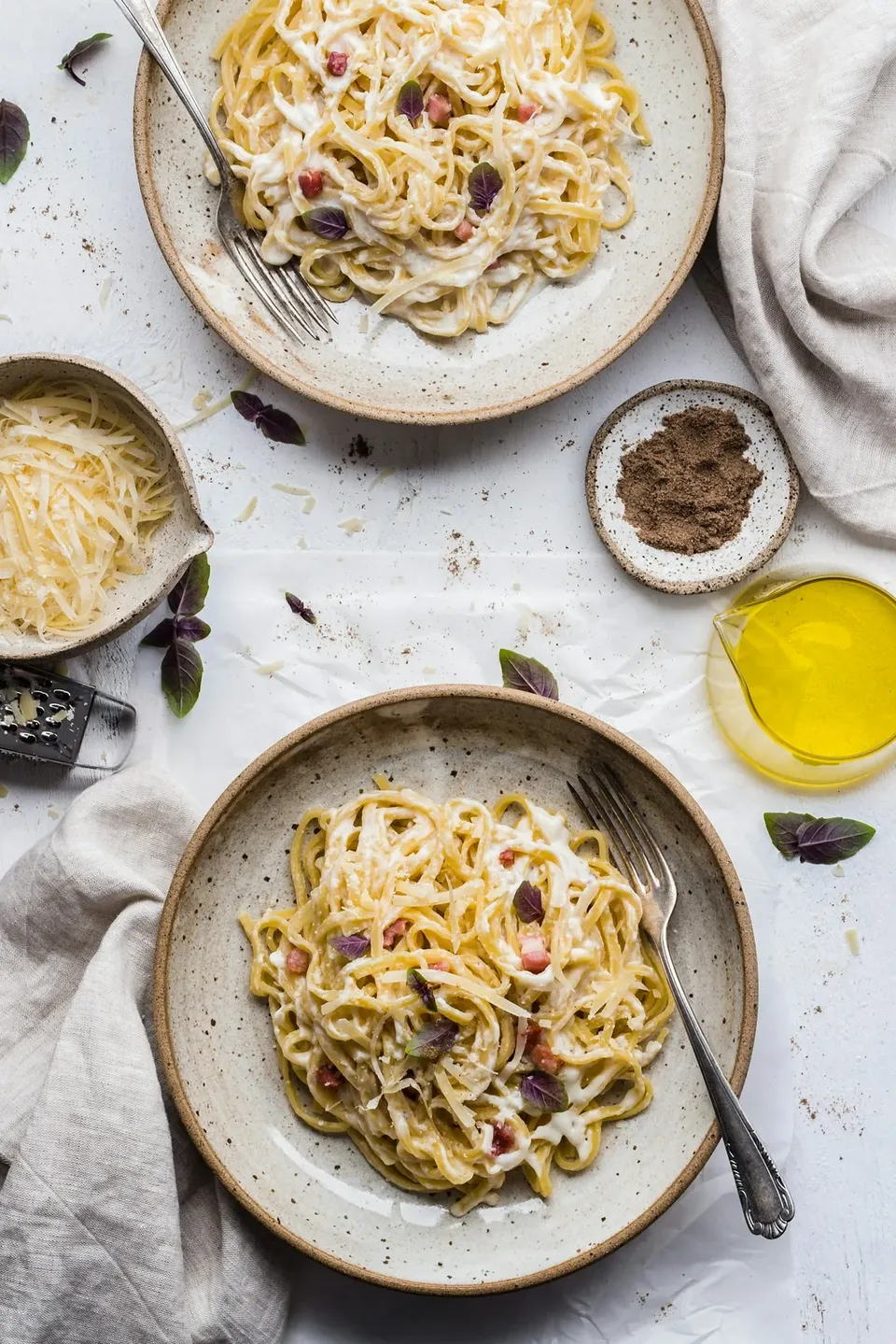 Two bowls of garlic butter spaghetti with parmesan